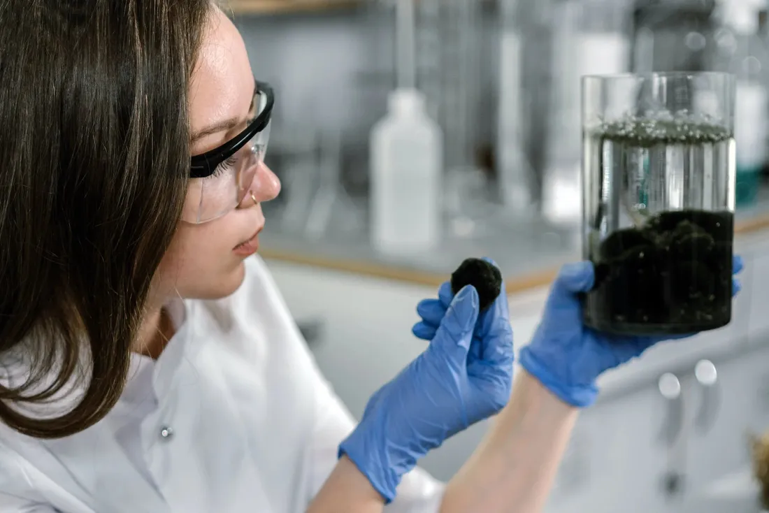 Ingénieure en blouse blanche analysant un échantillon en laboratoire